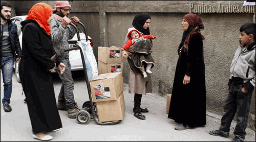 Varias personas guardan cola para recibir ayuda humanitaria iraní en el barrio de Al Zahira en Damasco (Siria). ©Youssef Badawi-efe