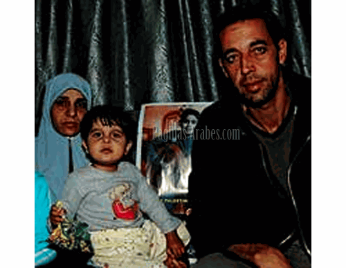 La familia. Ismael con su esposa, Um Mohamed, y la menor de sus vástagos, junto a una foto de Ahmed. «Tenía seis hijos», asegura.«Ahora tengo cinco más los otros cinco que Ahmed salvó».©El Mundo