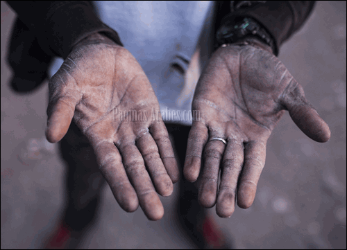 Un trabajador subsahariano de los invernaderos de Almería muestra sus manos en Níjar ©Santi Palacios